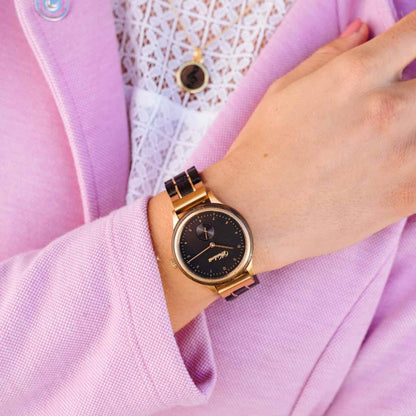 Dámske drevené hodinky Waidzeit Mystik Gold na rukách – kontrast mysticky čierneho duba a zlatej ocele vyžaruje eleganciu a silu prírody