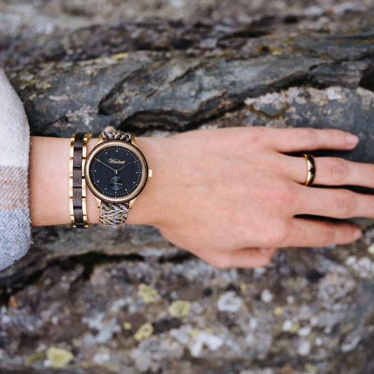 Dámske drevené hodinky Waidzeit Mystik Tweed na ruke – spojenie mystického duba bahna, zlatej ocele a elegantného ženského štýlu
