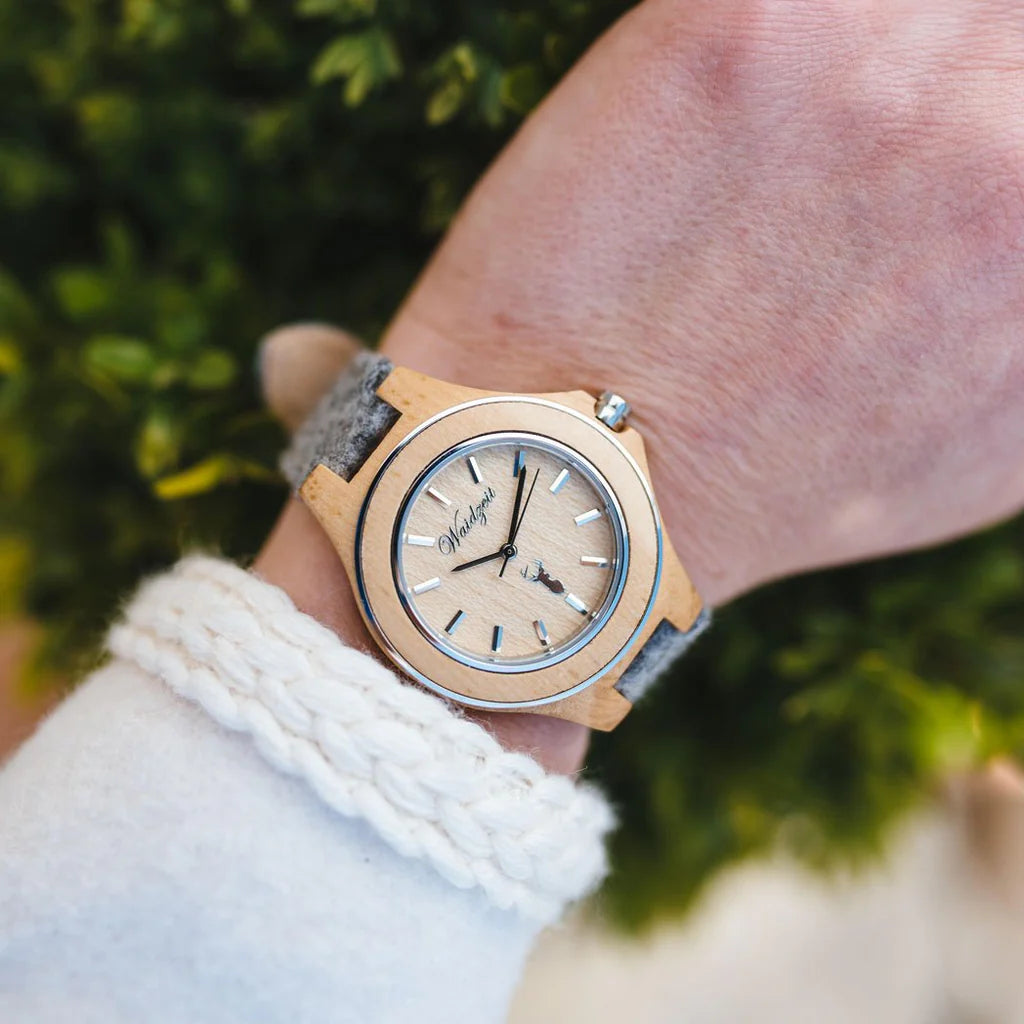 Detail dámskych drevených hodiniek Waidzeit Zirbenuhr – borovicové puzdro, oceľový krúžok a lodenový remienok Schladminger
