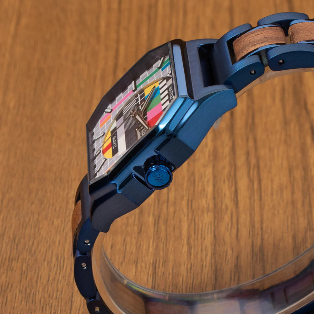 Detail drevených hodiniek Waidzeit Sendeschluss – orechové drevo, motív testovacieho obrazca a kráľovsky modrý náramok