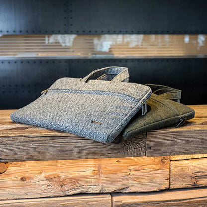 Jedna sivá a jedna zelená látková taška na drevenom povrchu s kovovým pozadím