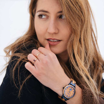 Detail dámskych drevených hodiniek Waidzeit RUM – teplé dubové drevo a modré kovové prvky vytvárajú harmonický kontrast