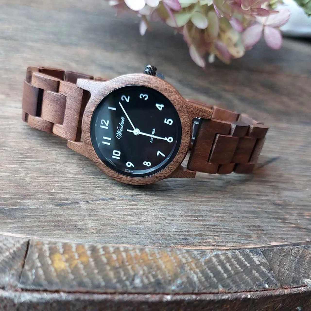 Detail dámskych drevených hodiniek Waidzeit Sissy Black – orechový ciferník, drevený remienok a jemné kovové prvky