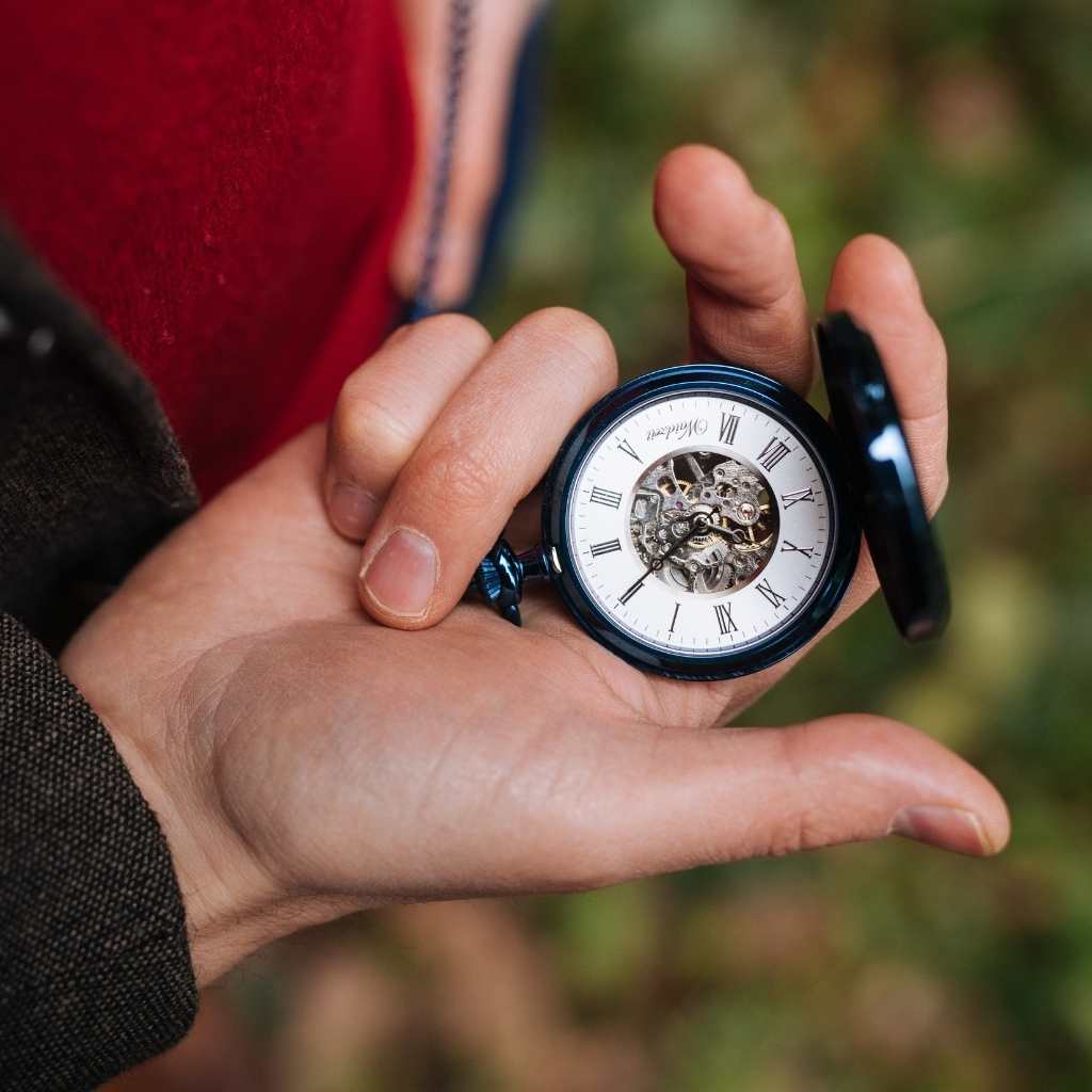 Drevené vreckové hodinky Waidzeit Skelett Blue v ruke – luxusné pánske vreckové hodinky so modrými detailmi a bielim ciferníkom